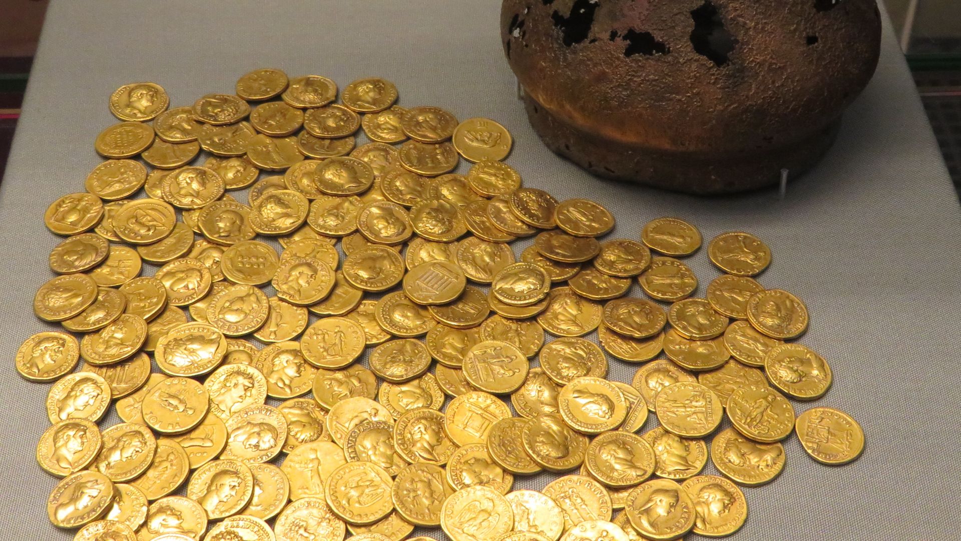 Hoard of 160 gold aureus coins in a bronze jug, with two bronze coins in the neck of the jug to disguise the worth of contents. Discovered below the floor of a Roman house in Corbridge, Northumberland in 1911. Circa AD 160. British Museum.