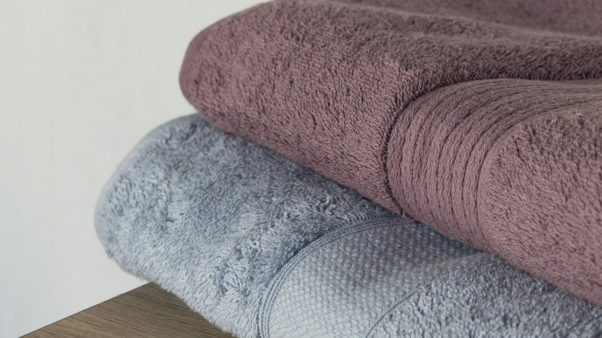 a stack of towels sitting on top of a wooden shelf