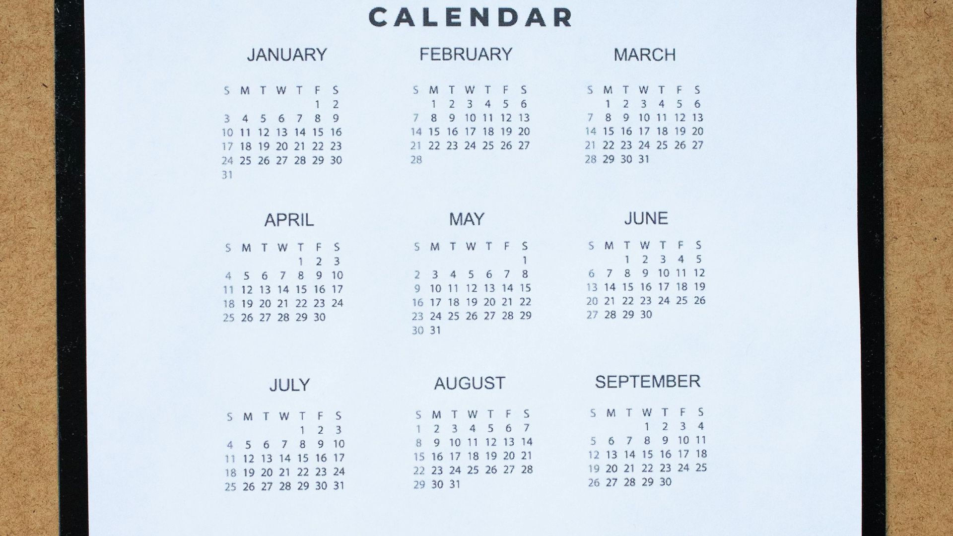 A top-down view of a 2021 calendar on a clipboard against a brown surface, perfect for planning and organization themes.