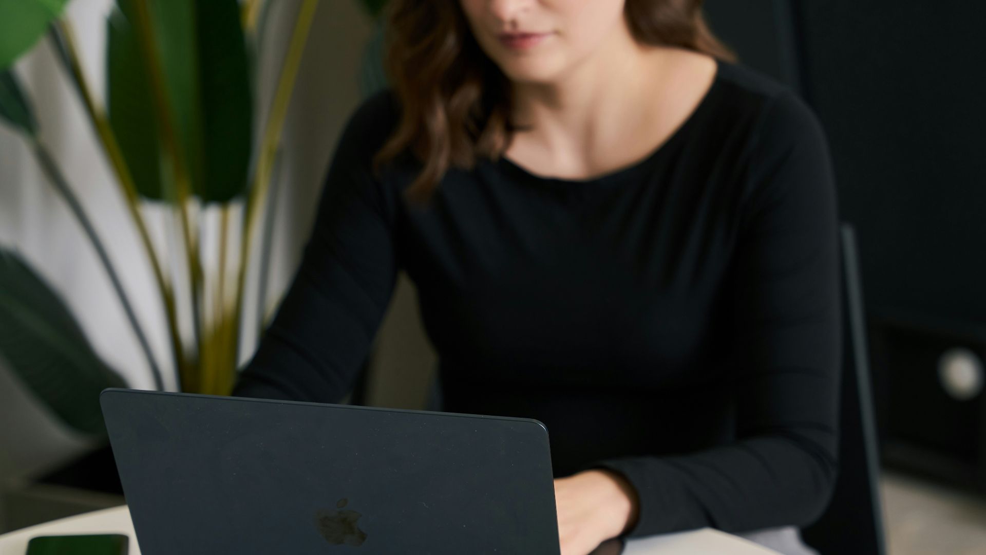 a woman sitting at a table with a laptop