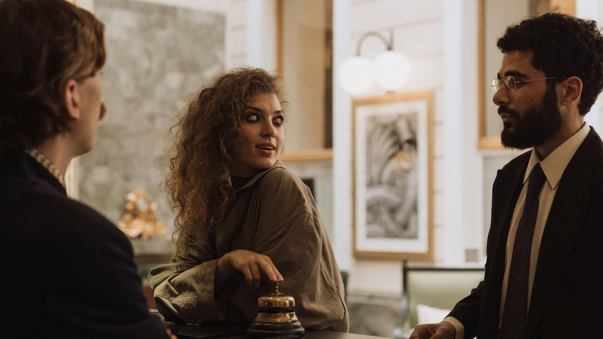 Guests interacting at a luxurious hotel reception desk, emphasizing hospitality and service.