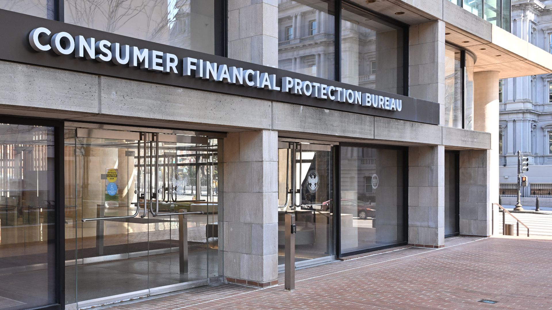 The entrance to the Consumer Financial Protection Bureau headquarters with the bureau's name above it. 1700 G Street NW, Washington, DC 20552.