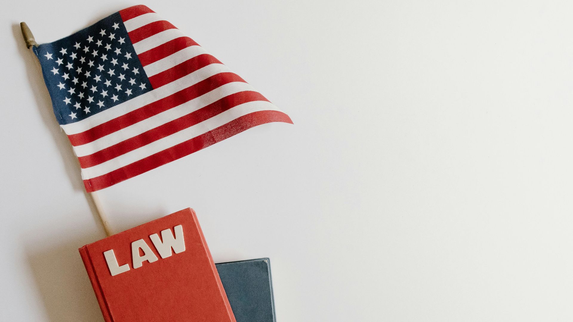 Flat lay of an American flag and a law book symbolizing justice and patriotism.