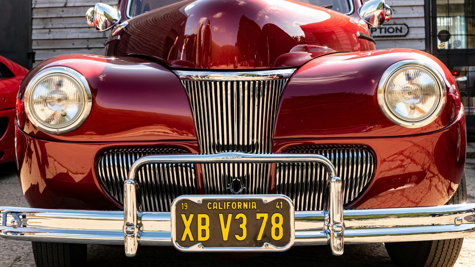 Front view of a shiny red vintage 1941 Ford parked outdoors in California.