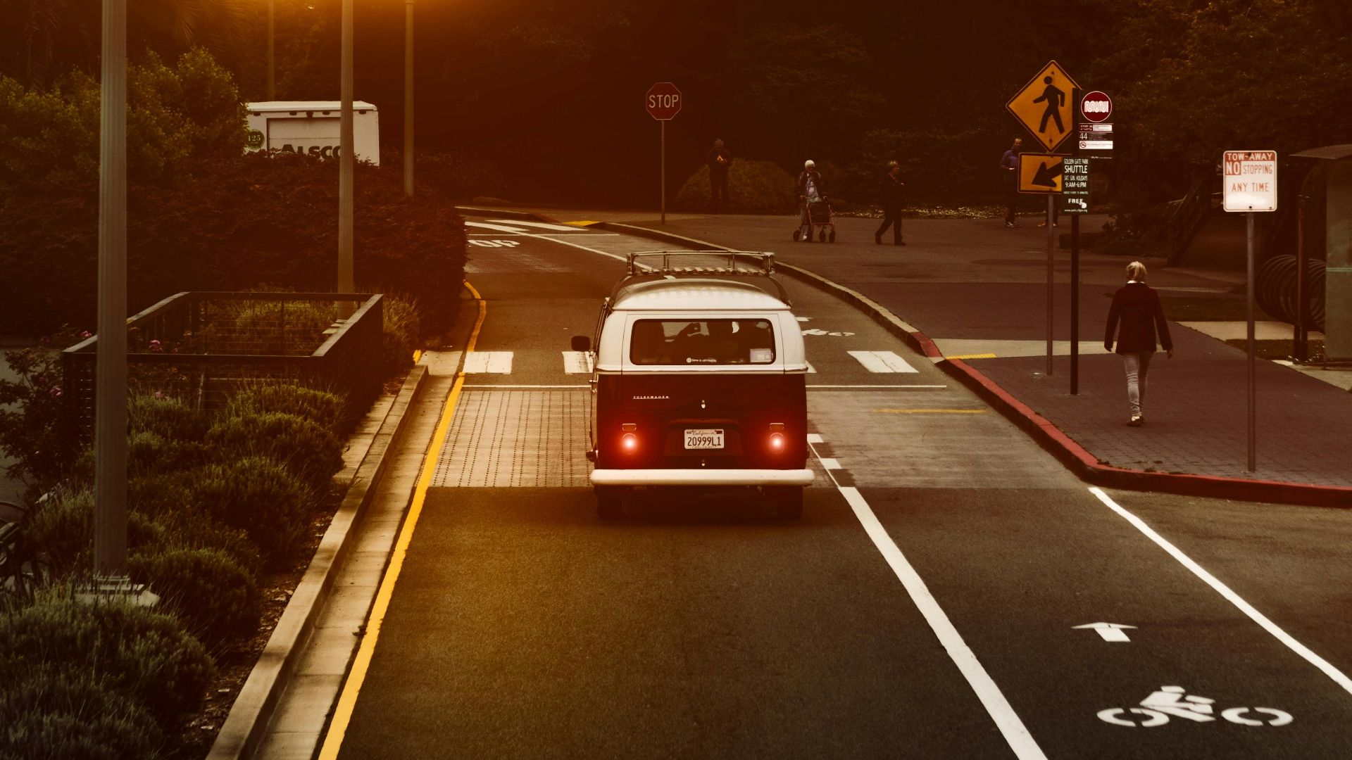 A vintage van journeys through San Francisco under warm streetlights at twilight.