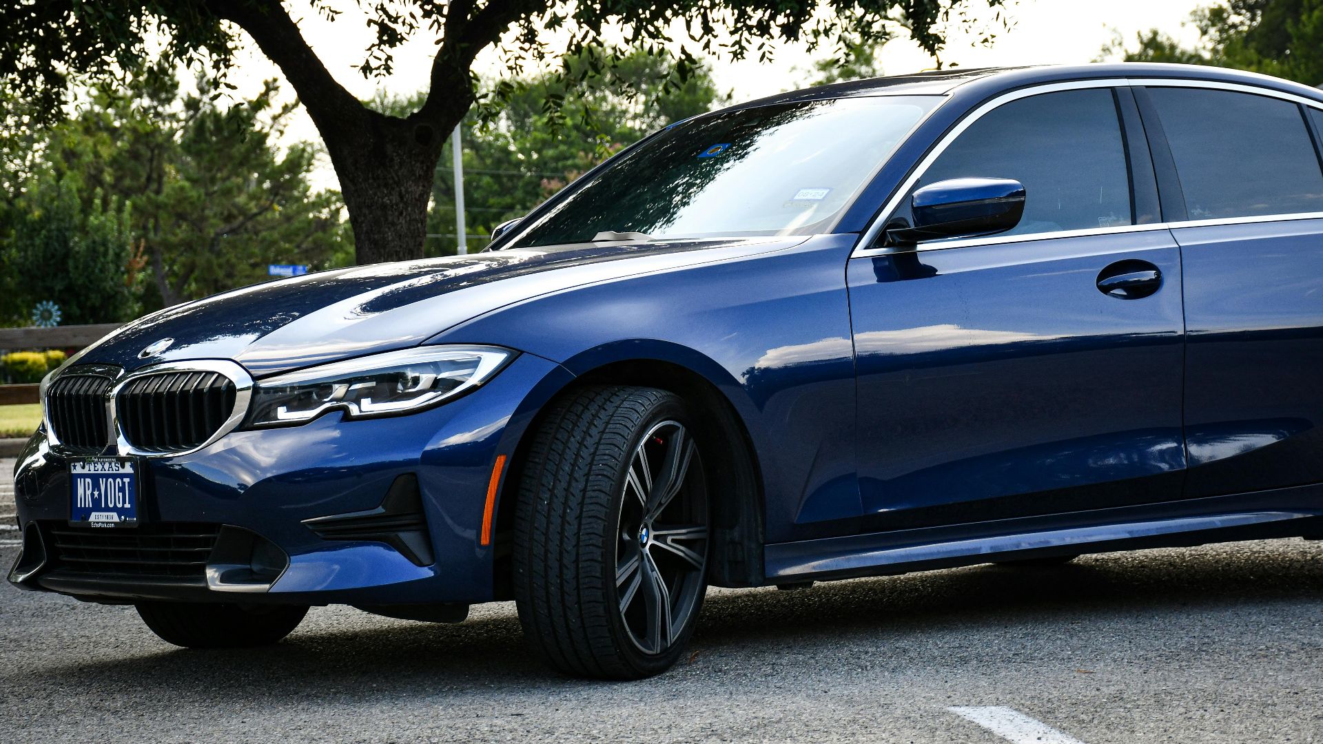 Blue sedan parked outdoors on a summer day in Arlington, Texas, showcasing luxury design and style.