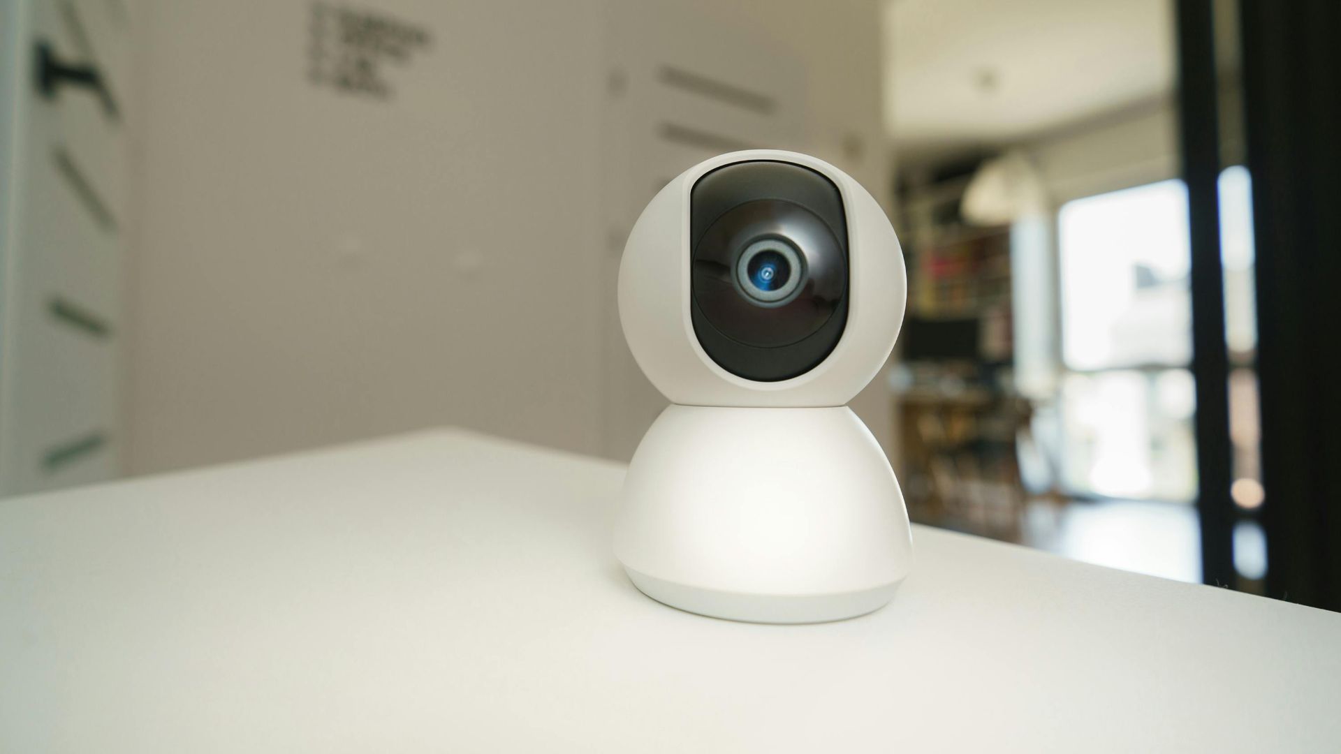 Close-up of a smart home surveillance camera on a table in an interior setting