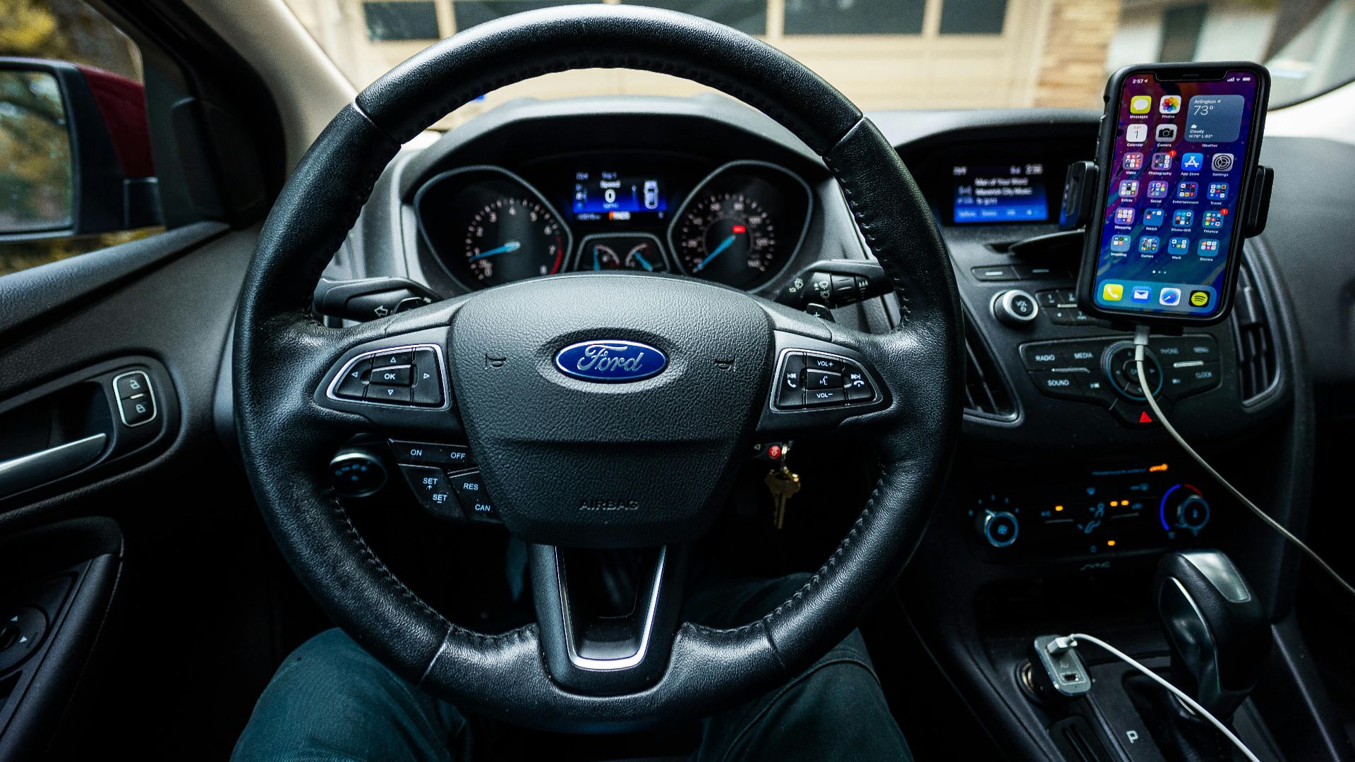 Interior view of a Ford car featuring a steering wheel, dashboard, and mobile device mount.