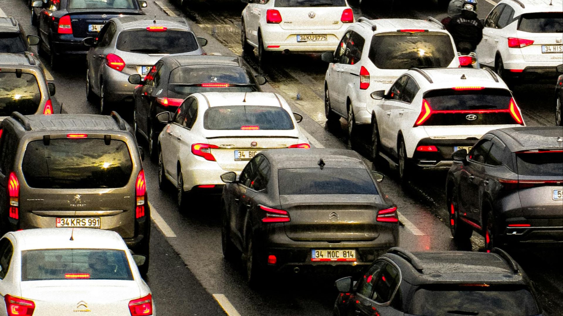 Dense traffic jam in a busy city street with numerous cars and high-rise buildings.