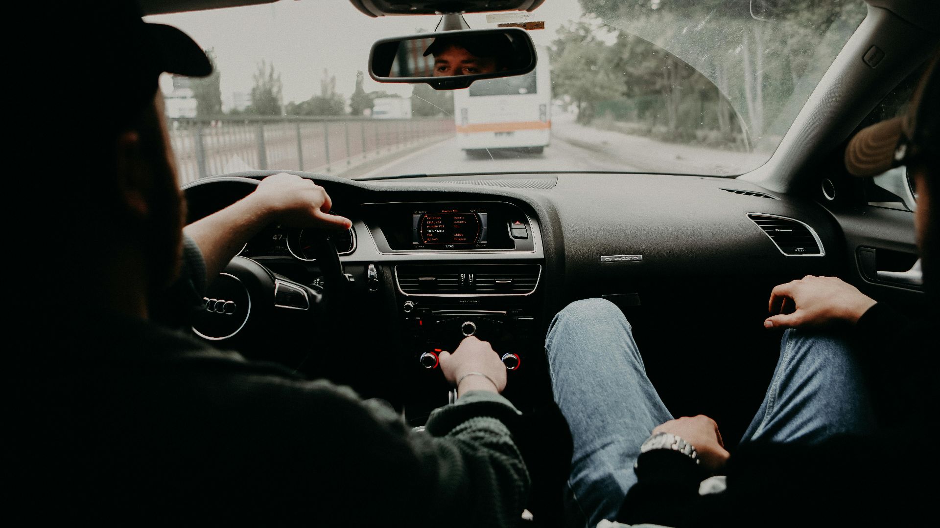 View from inside a moving car with two men traveling on a road trip.
