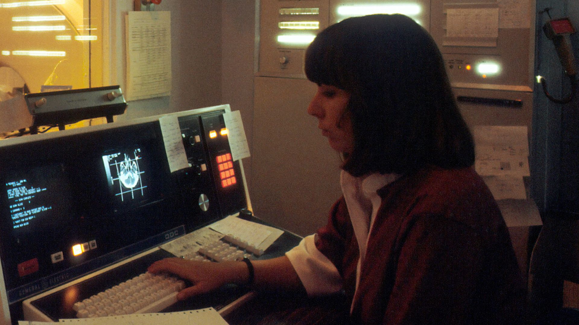 woman in red shirt sitting in front of computer