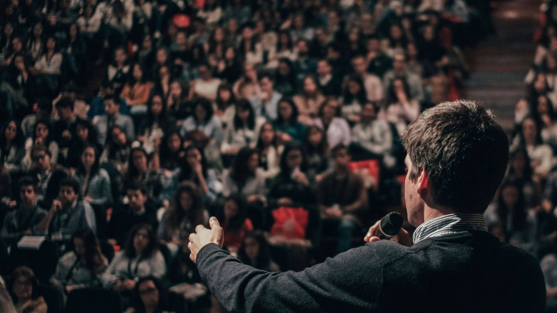 man speaking in front of crowd