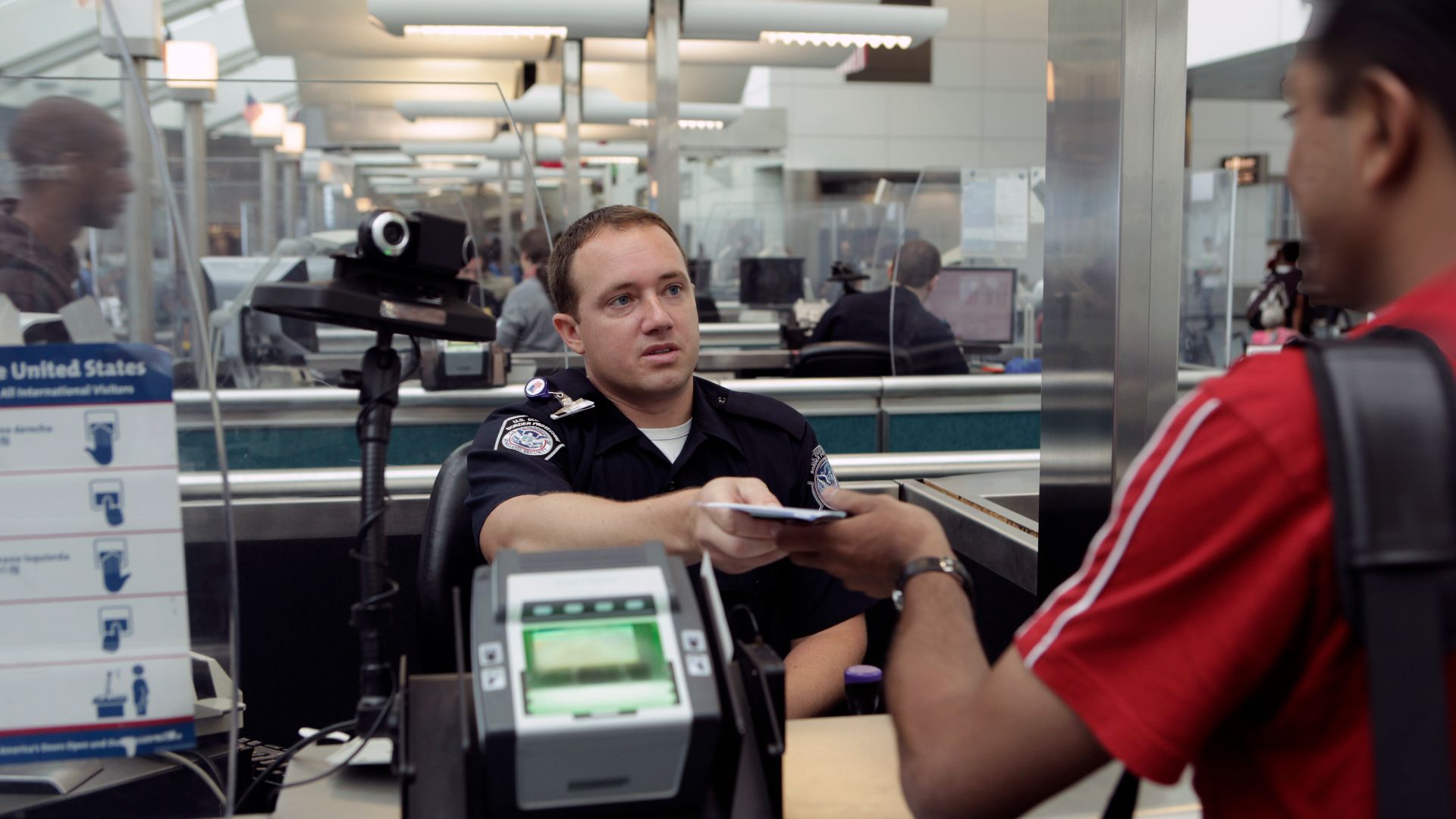 A CBP Officer processes an incoming passenger at the Newark International Airport.  Photo by James Tourtellotte