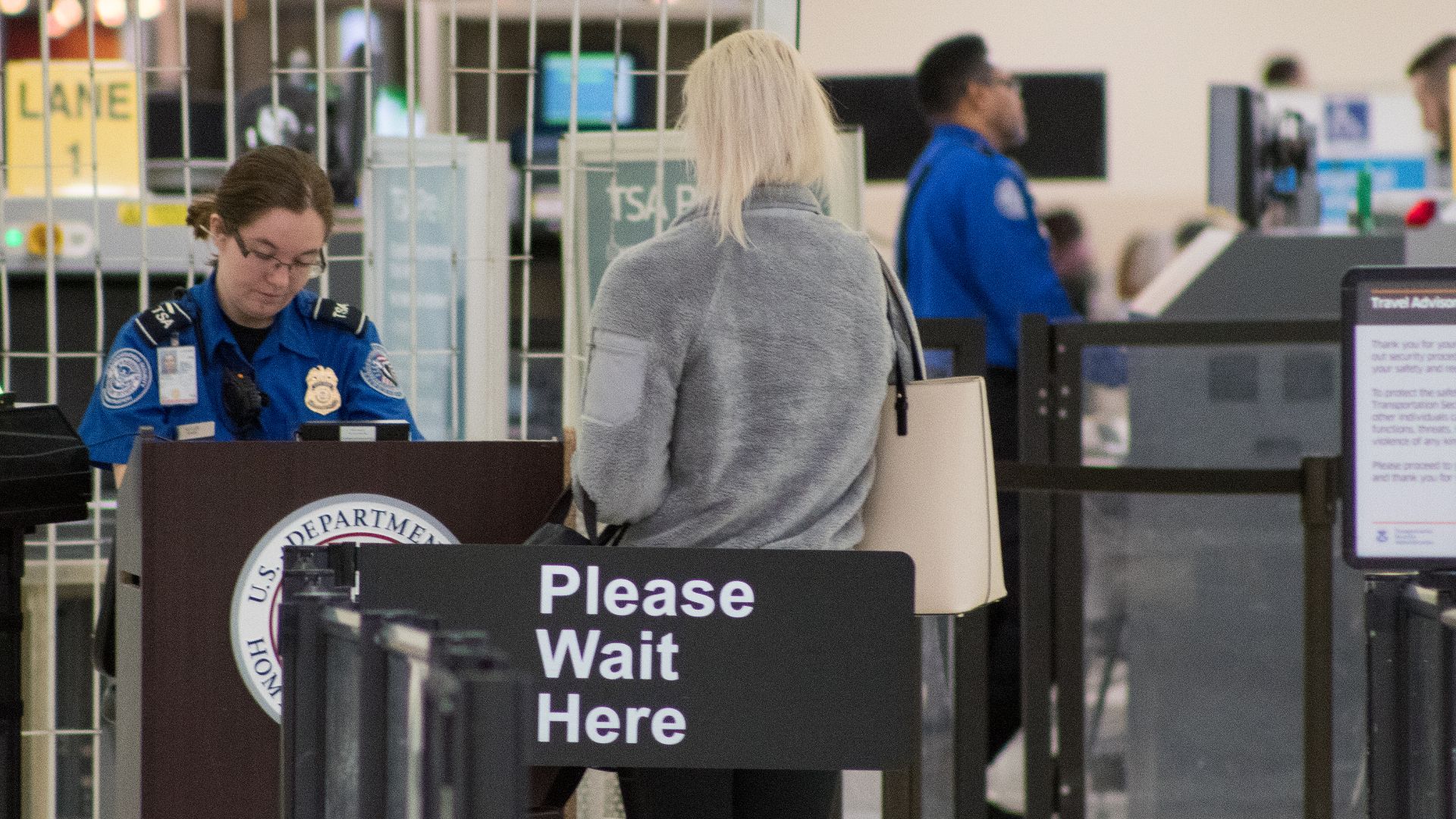 A Transportation Security Administration agent at a checkpoint verifying passenger identification, John Glenn Columbus International Airport