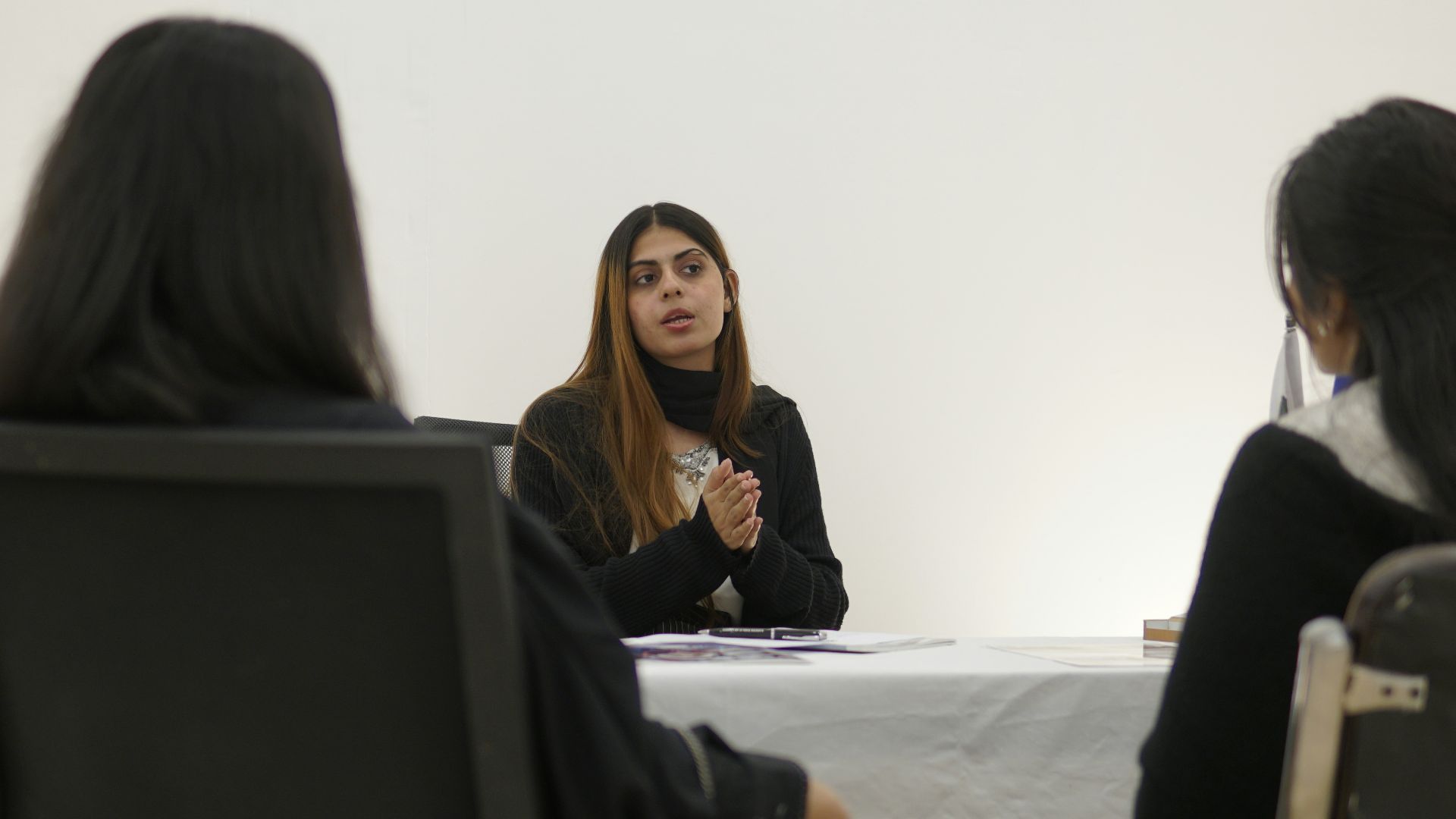 Woman speaking to two people across table