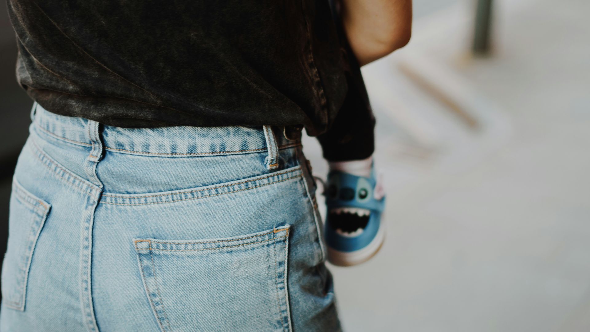 a person wearing blue jeans and a black shirt