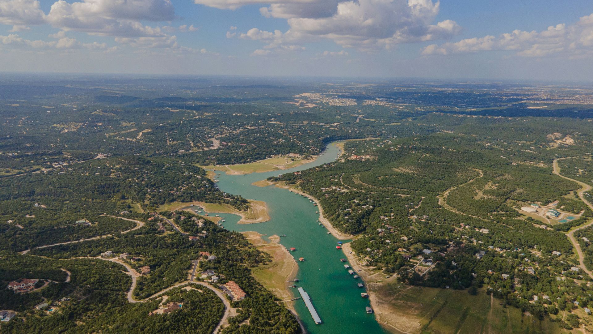aerial view of green field and body of water during daytime