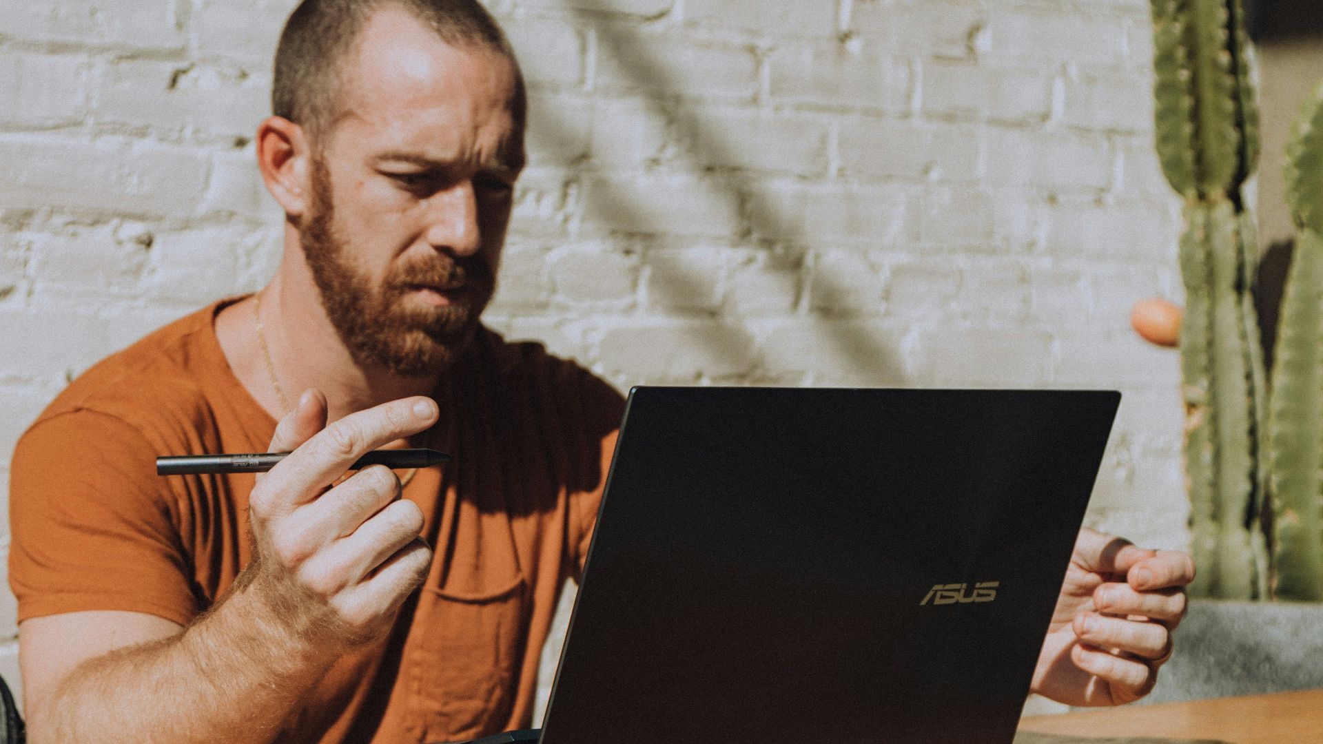 a man sitting at a table using a laptop computer