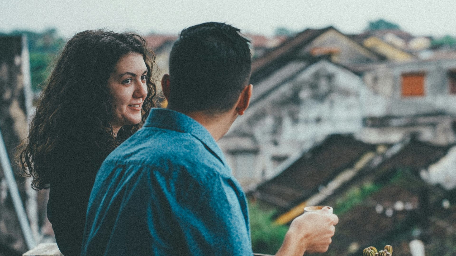 Couple enjoying coffee overlooking old town rooftops