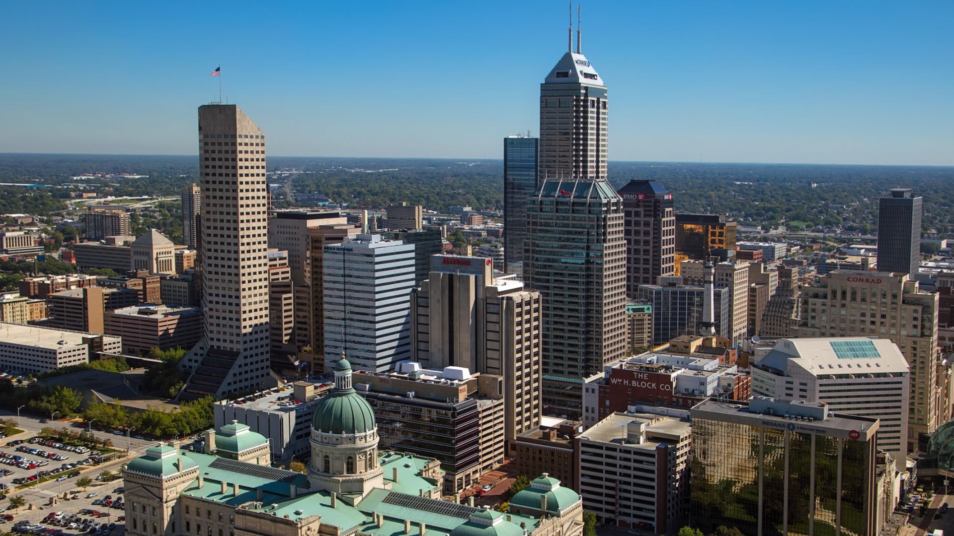 Aerial looking east northeast across downtown Indianapolis. The Indiana Statehouse is visible in the foreground.