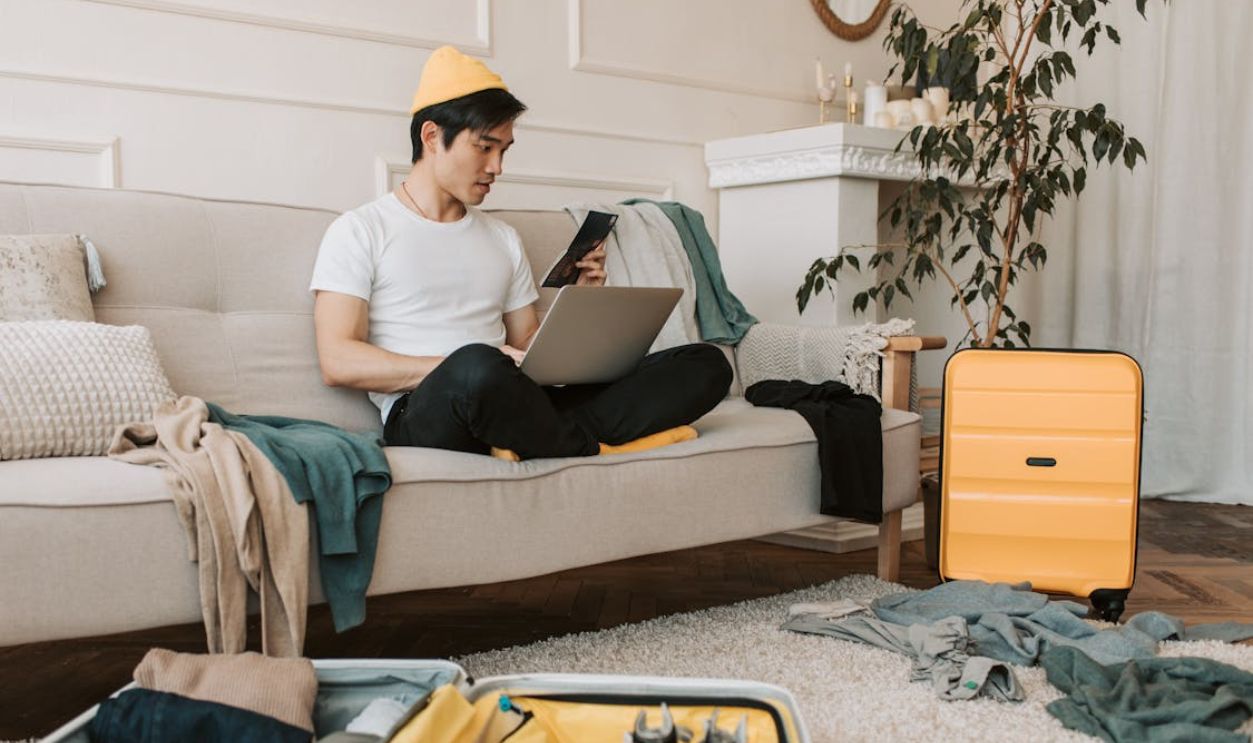 A Man Sitting on the Couch while Using Laptop
