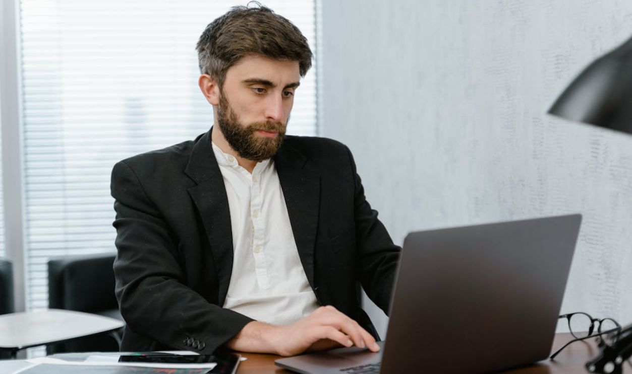 Man in Black Suit Jacket Using Laptop