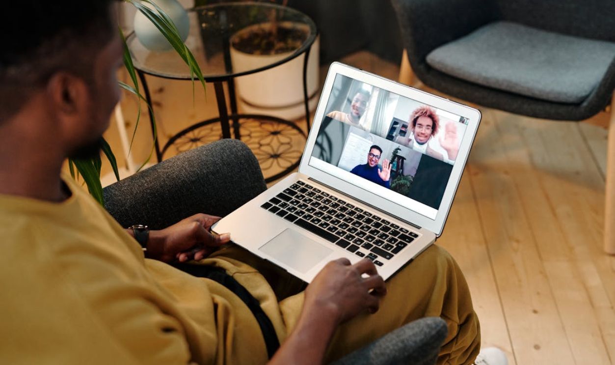 A Person in Yellow Shirt Sitting on Black Chair doing Video Call