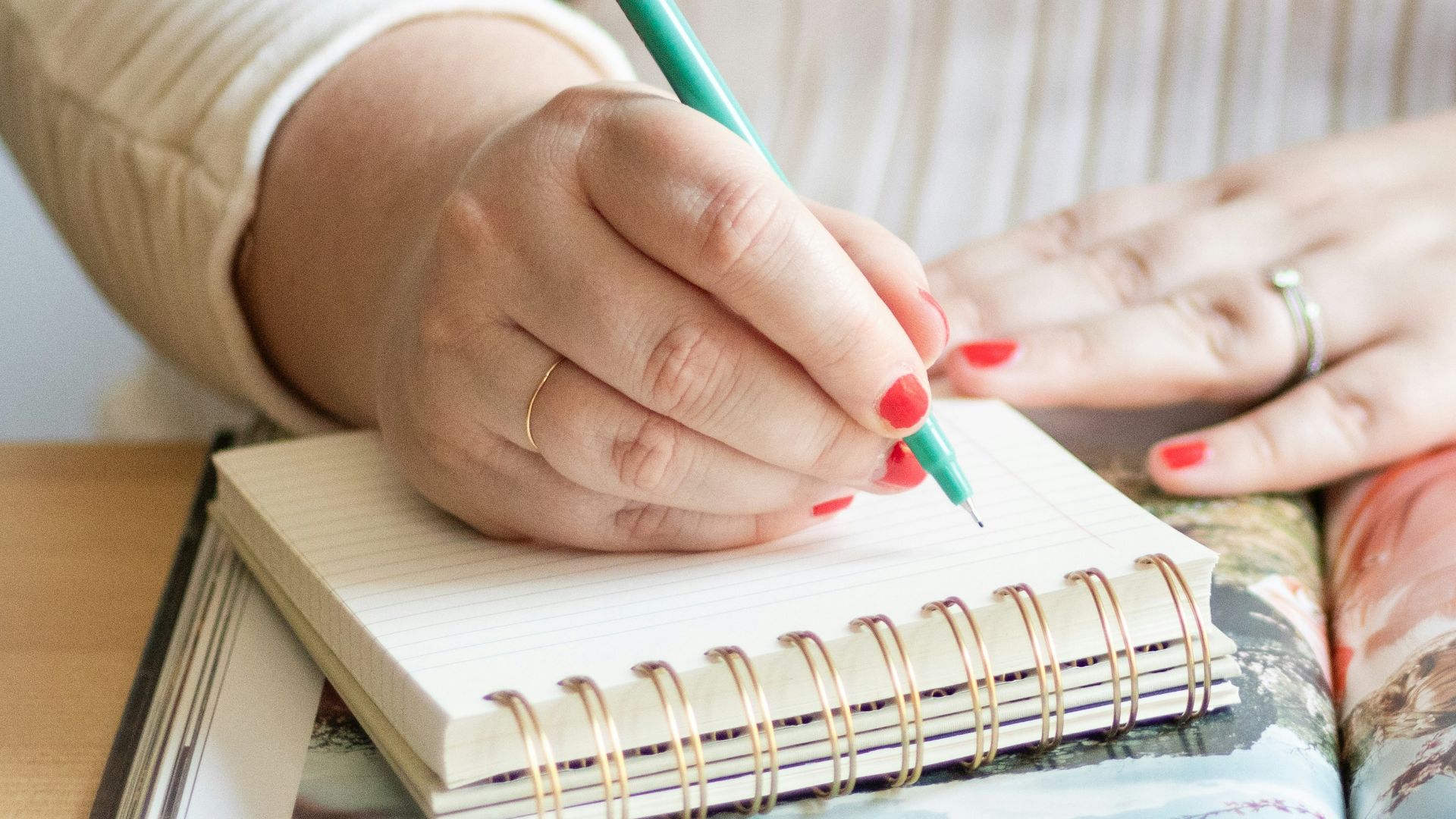 a woman is holding a pen and writing on a book