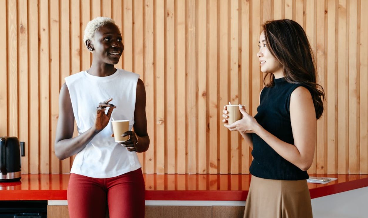 Diverse women with takeaway coffee in office