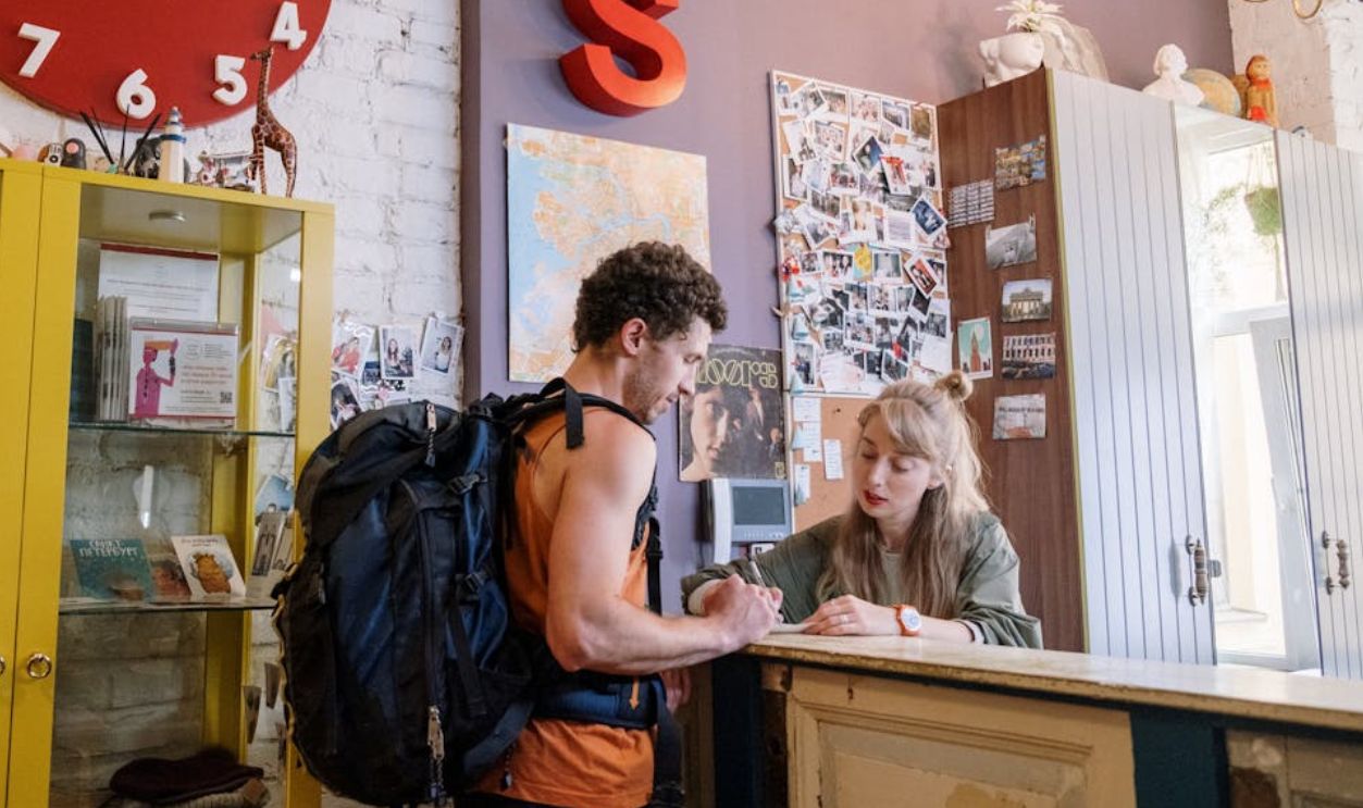 Tourist Standing in front of Reception Desk