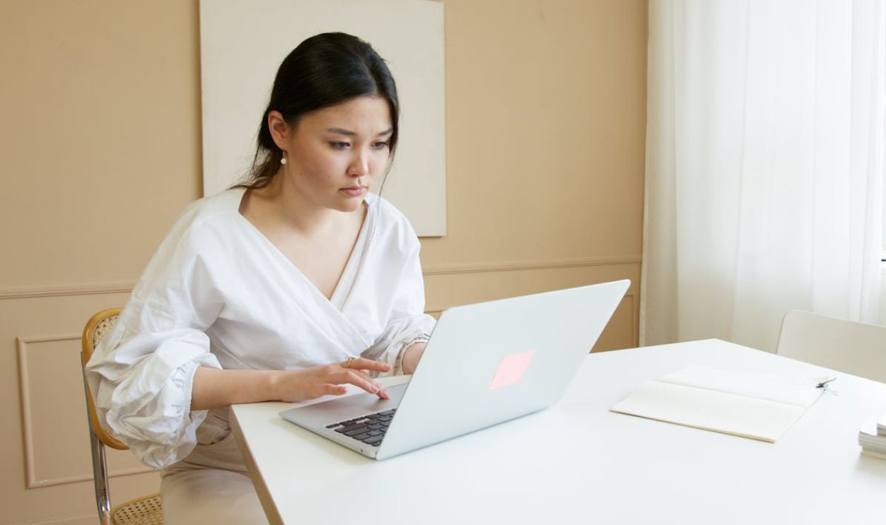 Woman in White Top Using Macbook Air