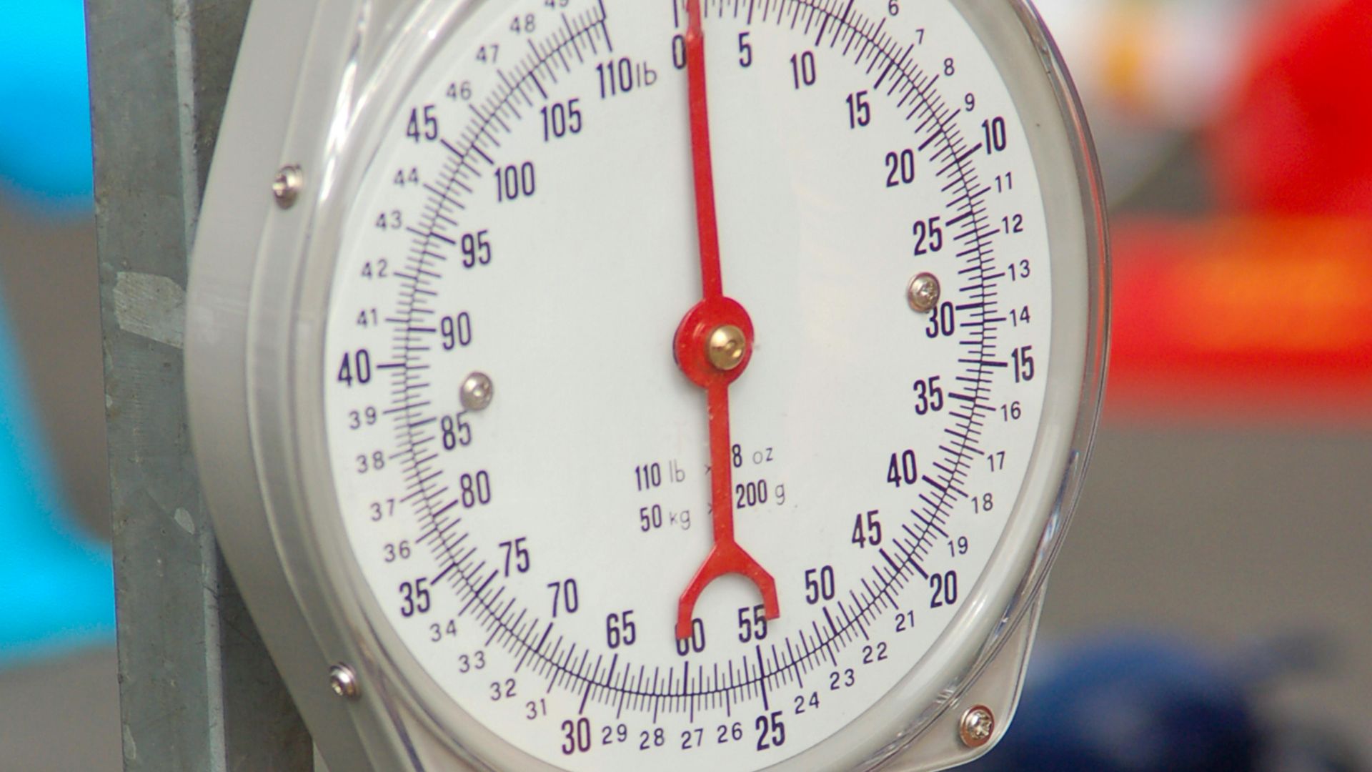 Close-up of a precision hanging scale with a metal hook for measuring weight accurately.