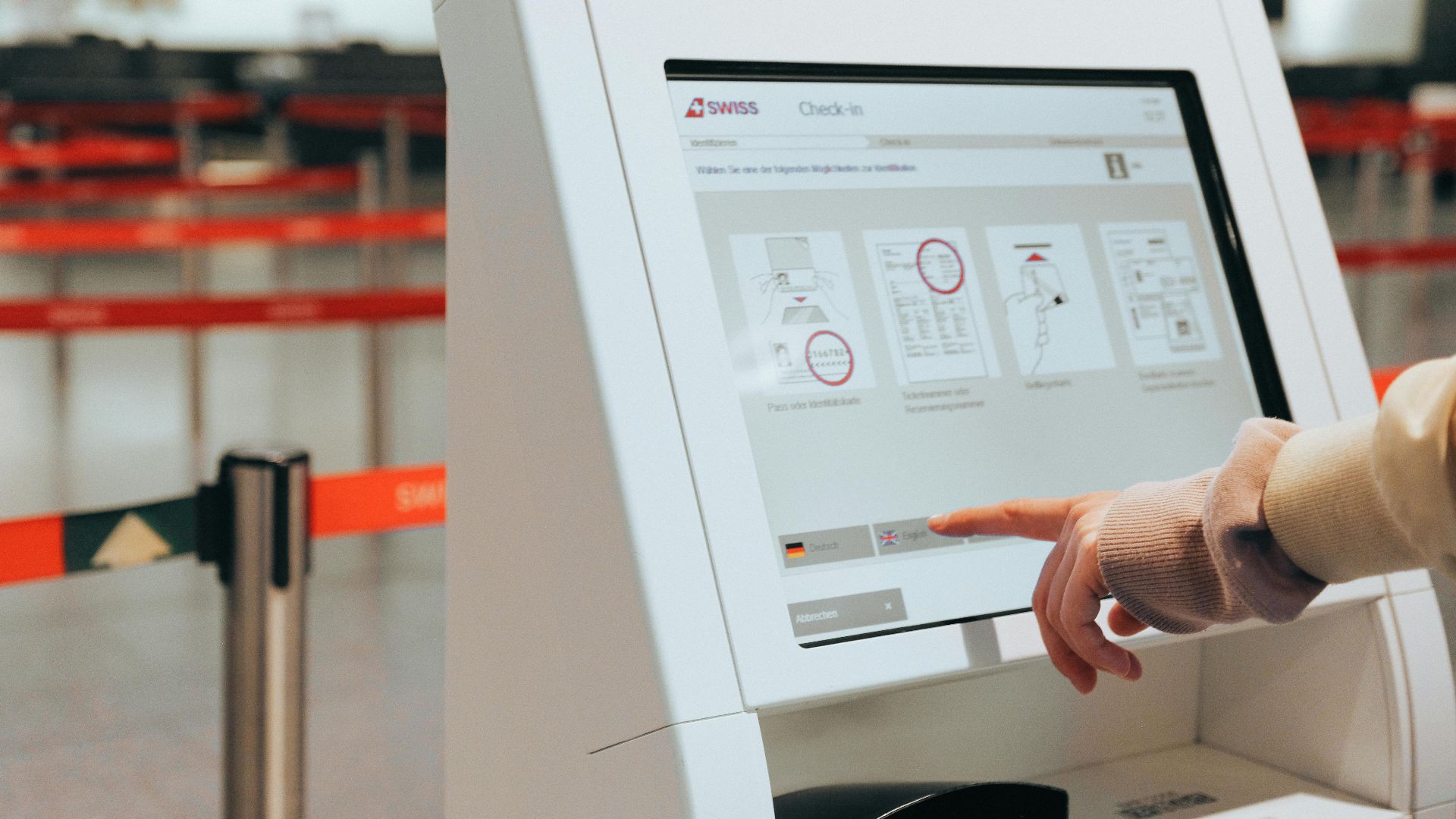 Passenger using self-service check-in kiosk at airport for convenient travel experience.