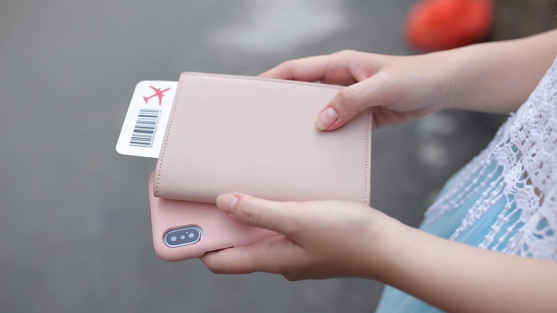 A woman holding a passport with a boarding pass and a smartphone, ready for travel.
