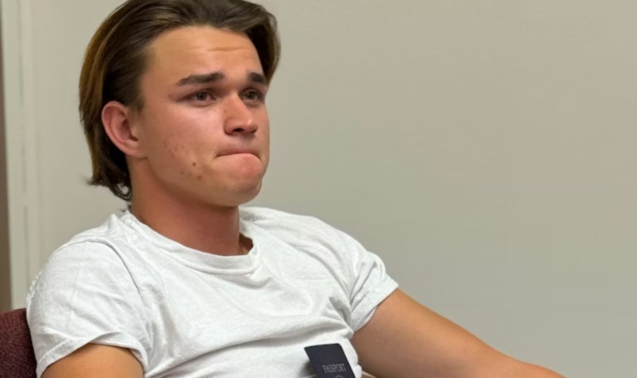 Young man holding passport, looking worried