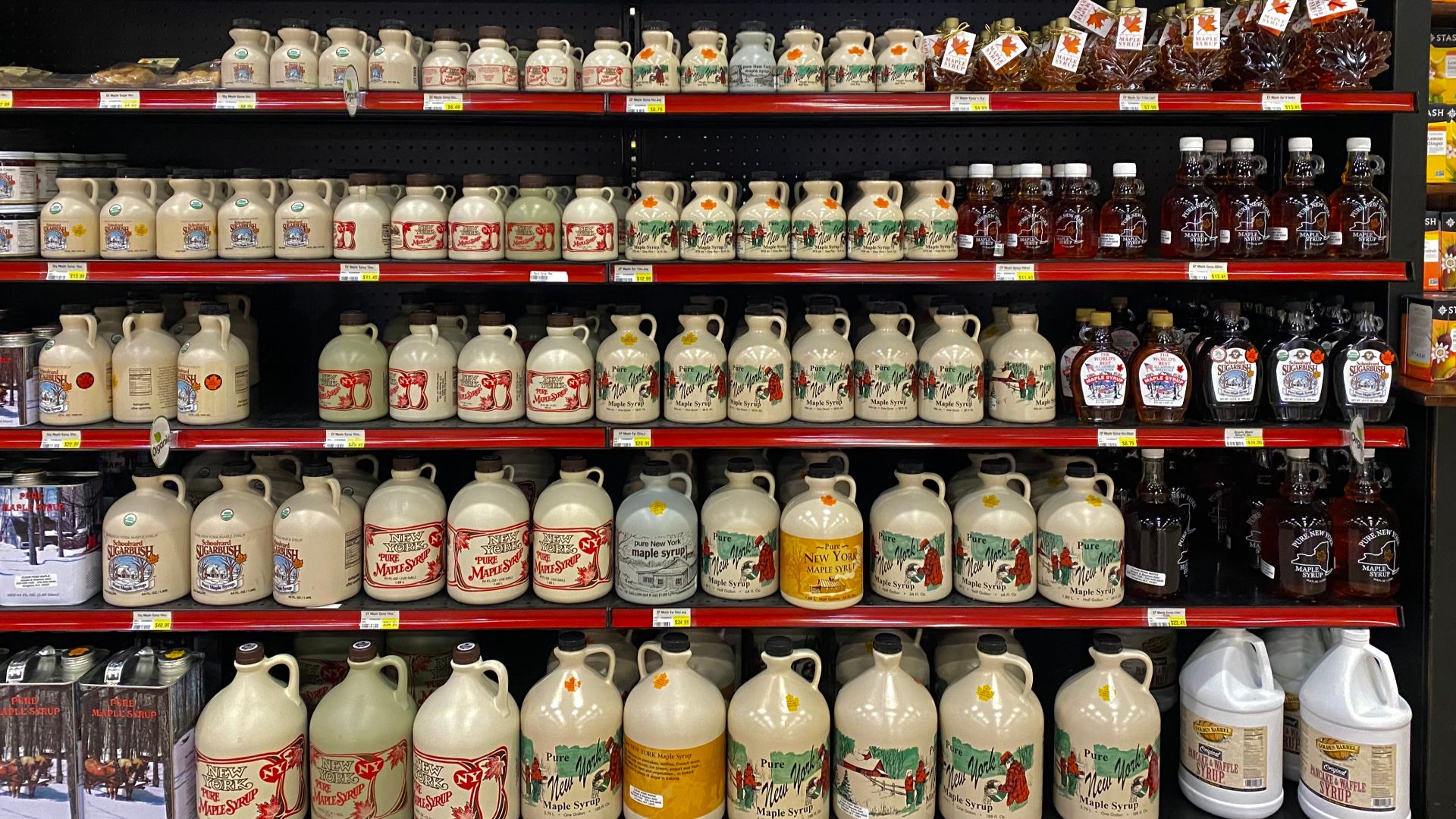 As seen in January 2023, a shelf stocked full of New York State maple syrup populates one of the aisles at Sauders Store, a Mennonite-owned supermarket in Seneca Falls, New York that has made a name for itself as a purveyor of such locally- and regionally-sourced food products. Although Vermont is the U.S. state most associated with maple syrup production, New York occupies a solid second place, with nearly three million taps producing an average of about 800,000 gallons a year.
