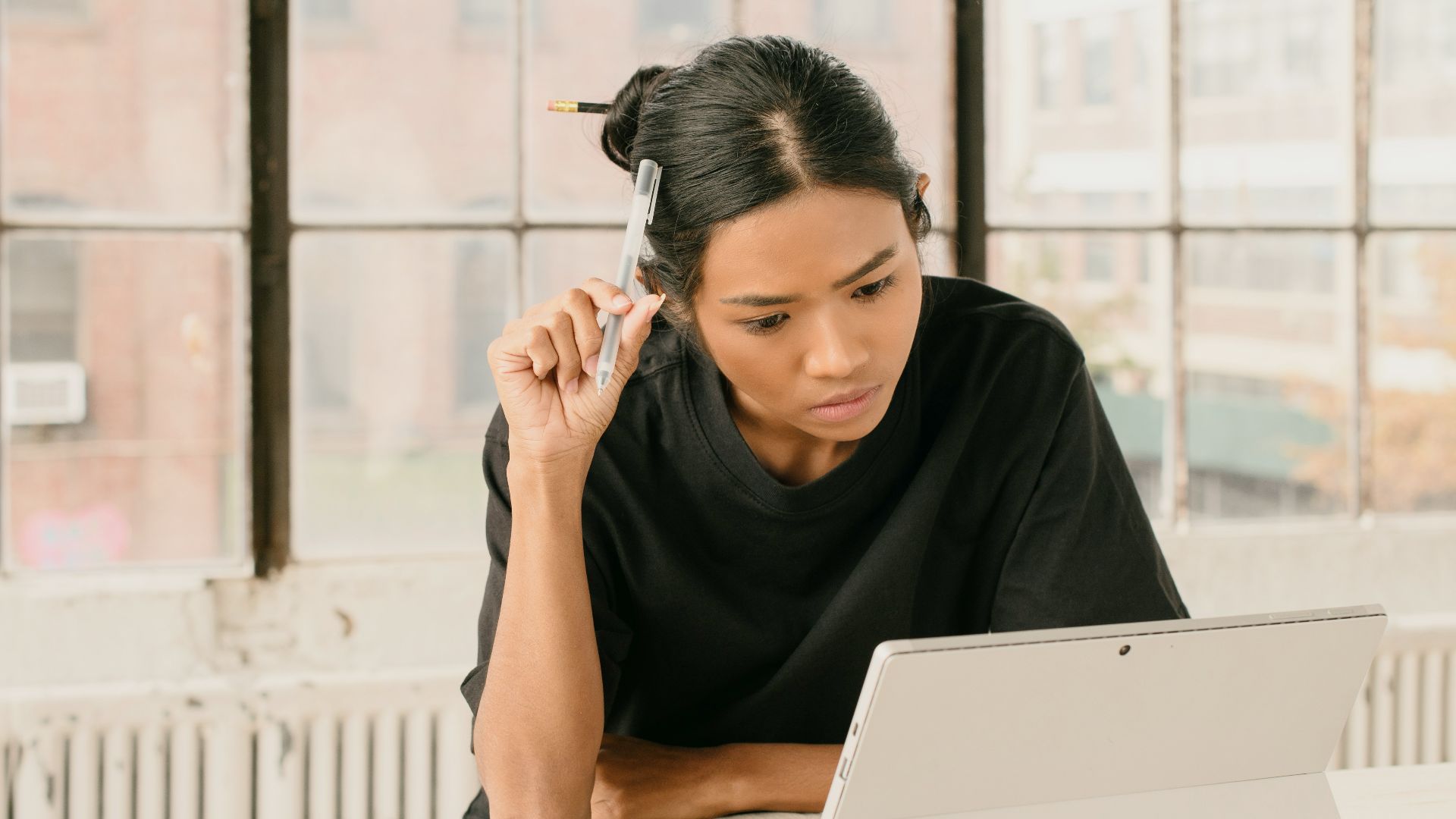 a woman sitting at a table using a laptop computer