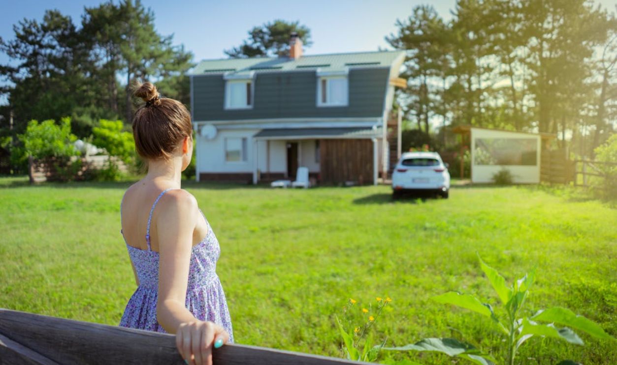 Woman Looking at House with Green Lawn