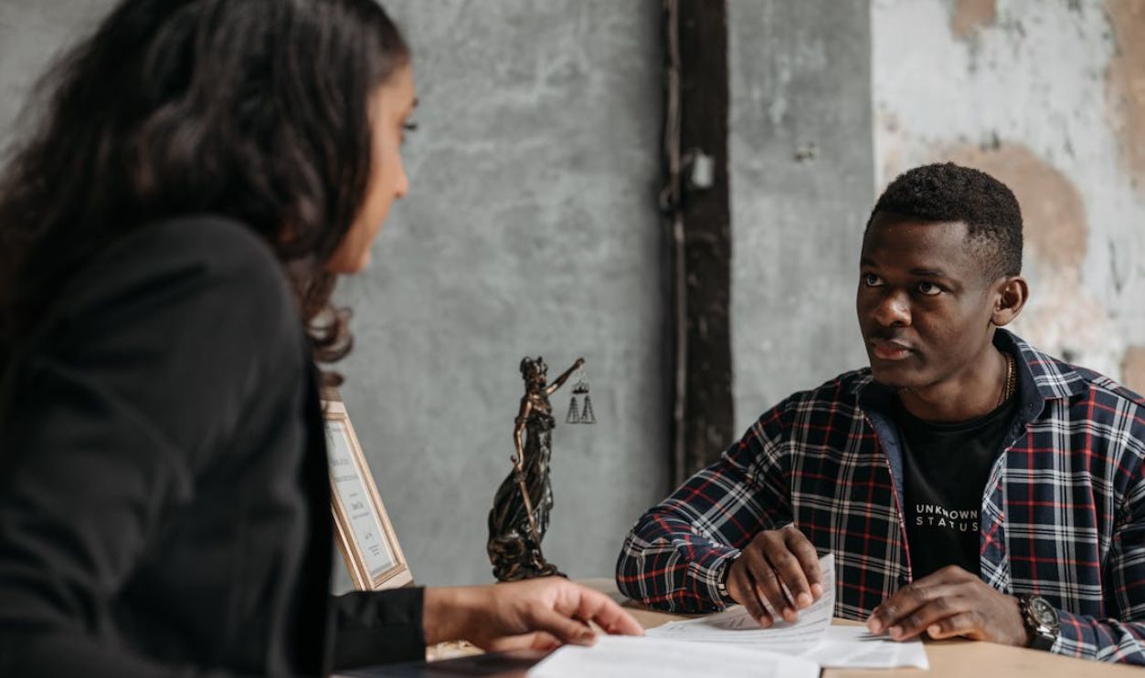 A Man in Checkered Long Sleeves Talking to His Lawyer