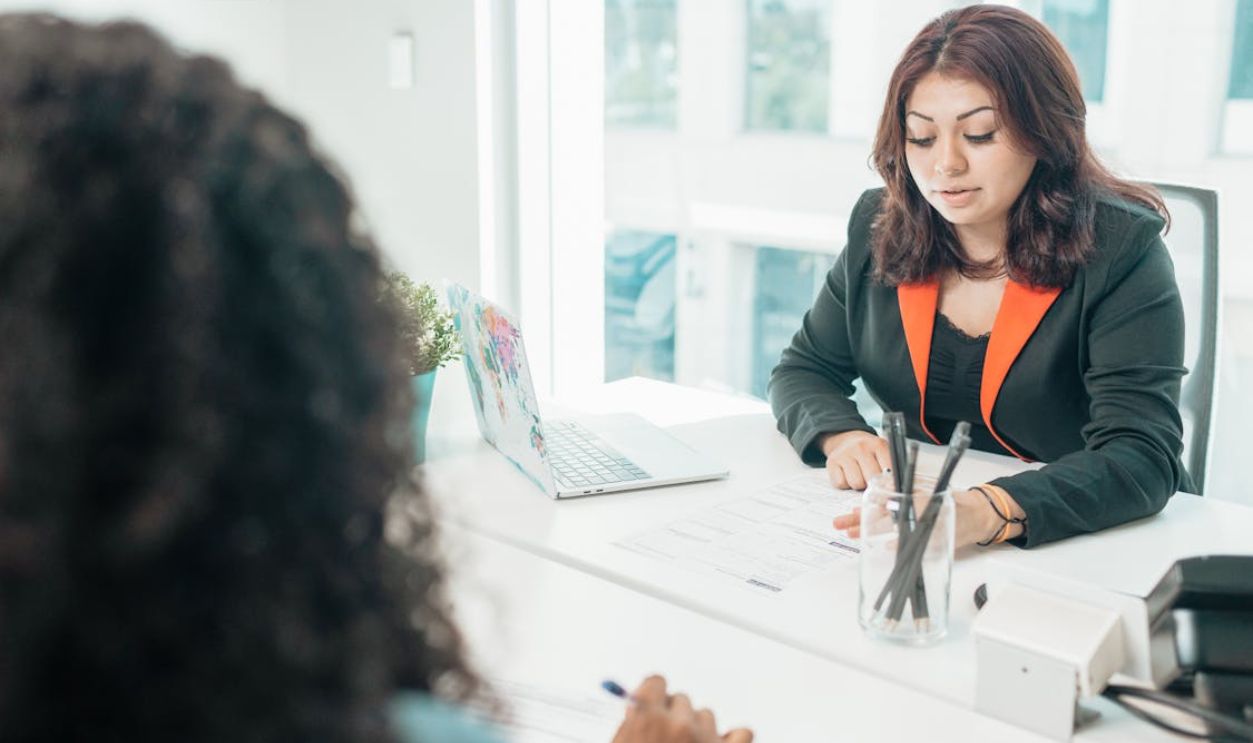 A Woman in Black Suit Sitting at the Table