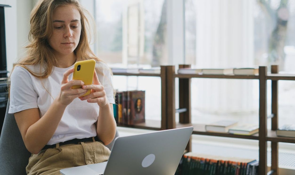 A Woman in White Shirt using a Smartphone