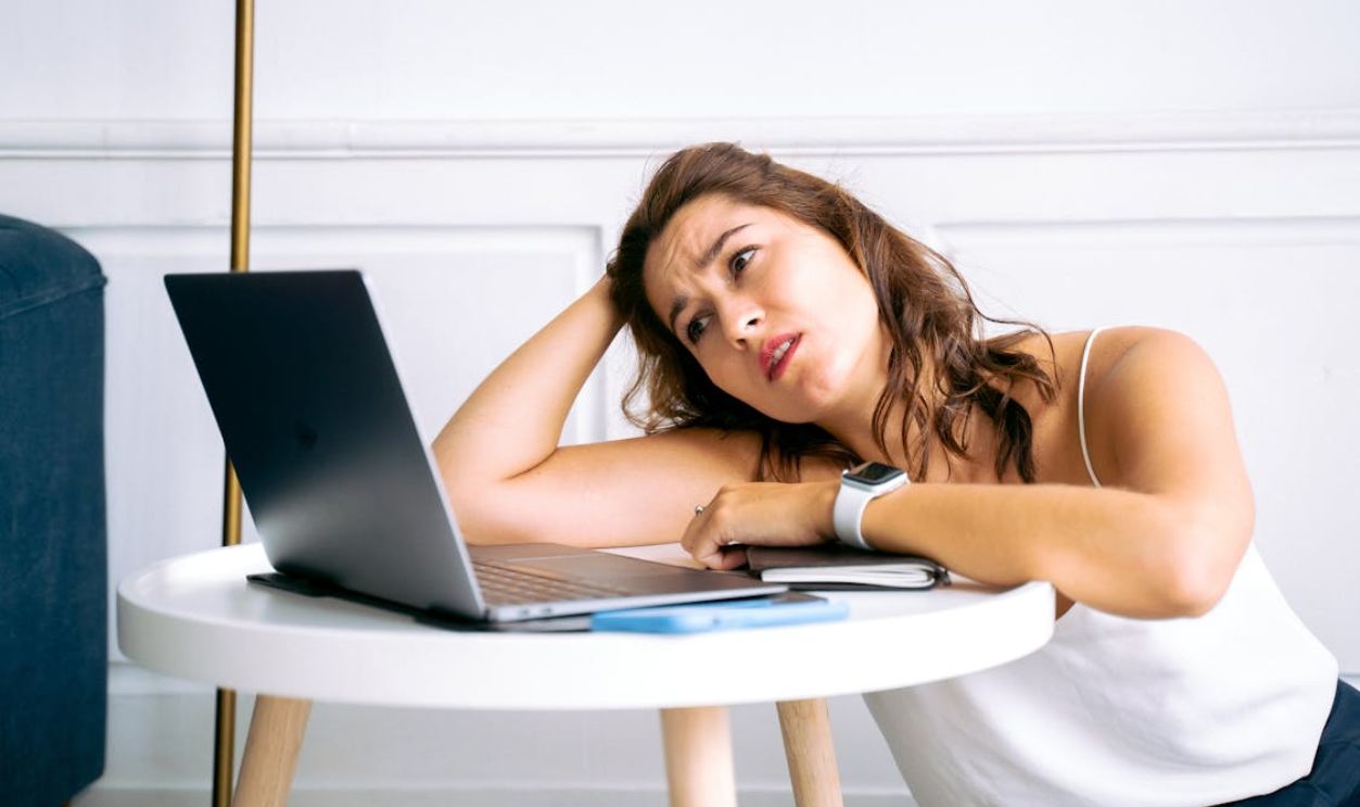 Woman in White Top Looking at a Laptop Screen