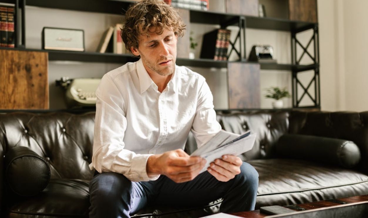 Man in White Long Sleeve Shirt Sitting on Sofa