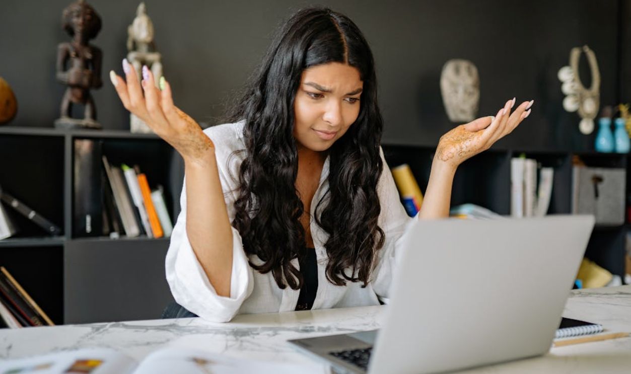 A Woman in White Long Sleeves Using a Laptop