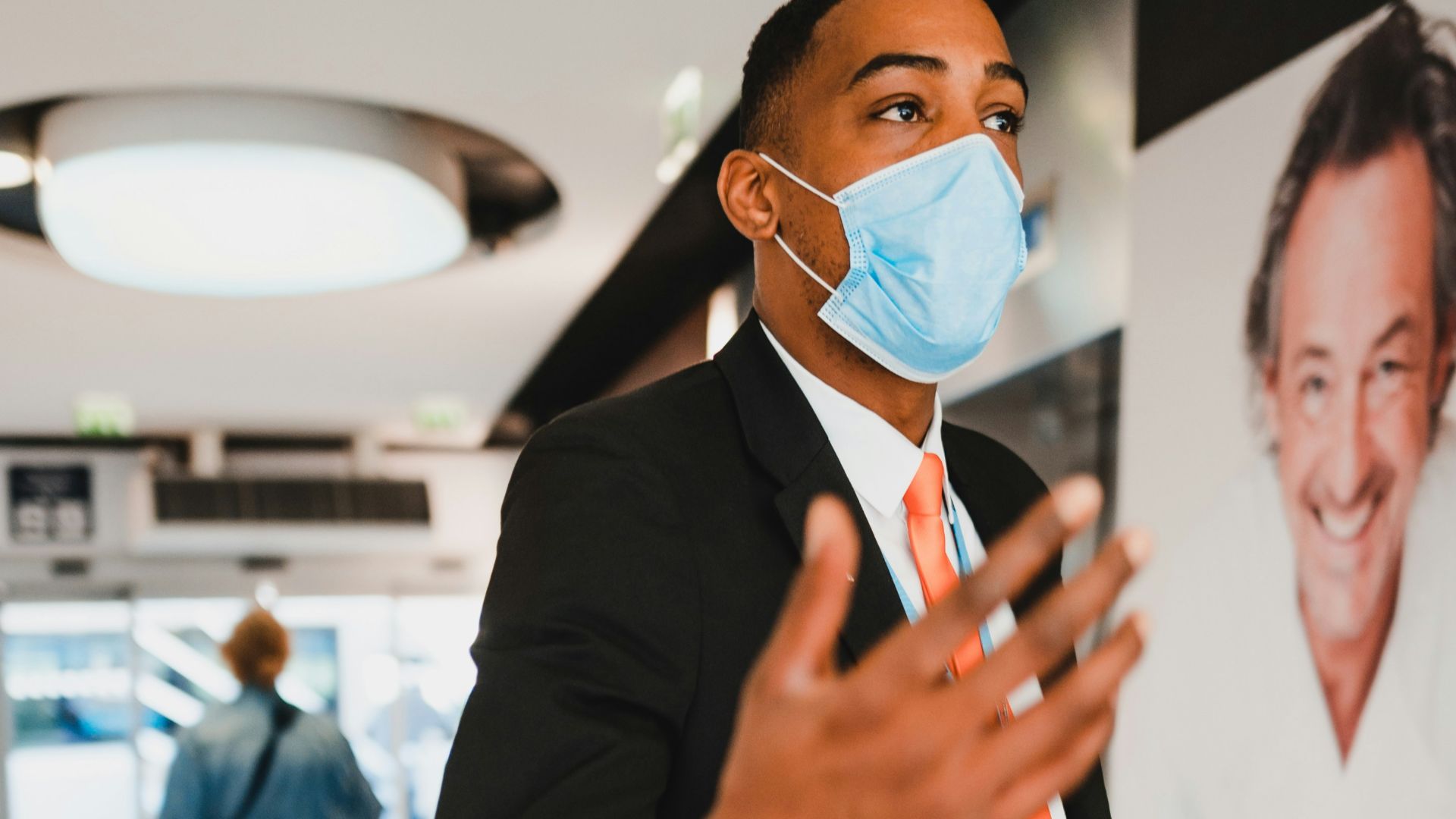 man in black blazer holding white paper