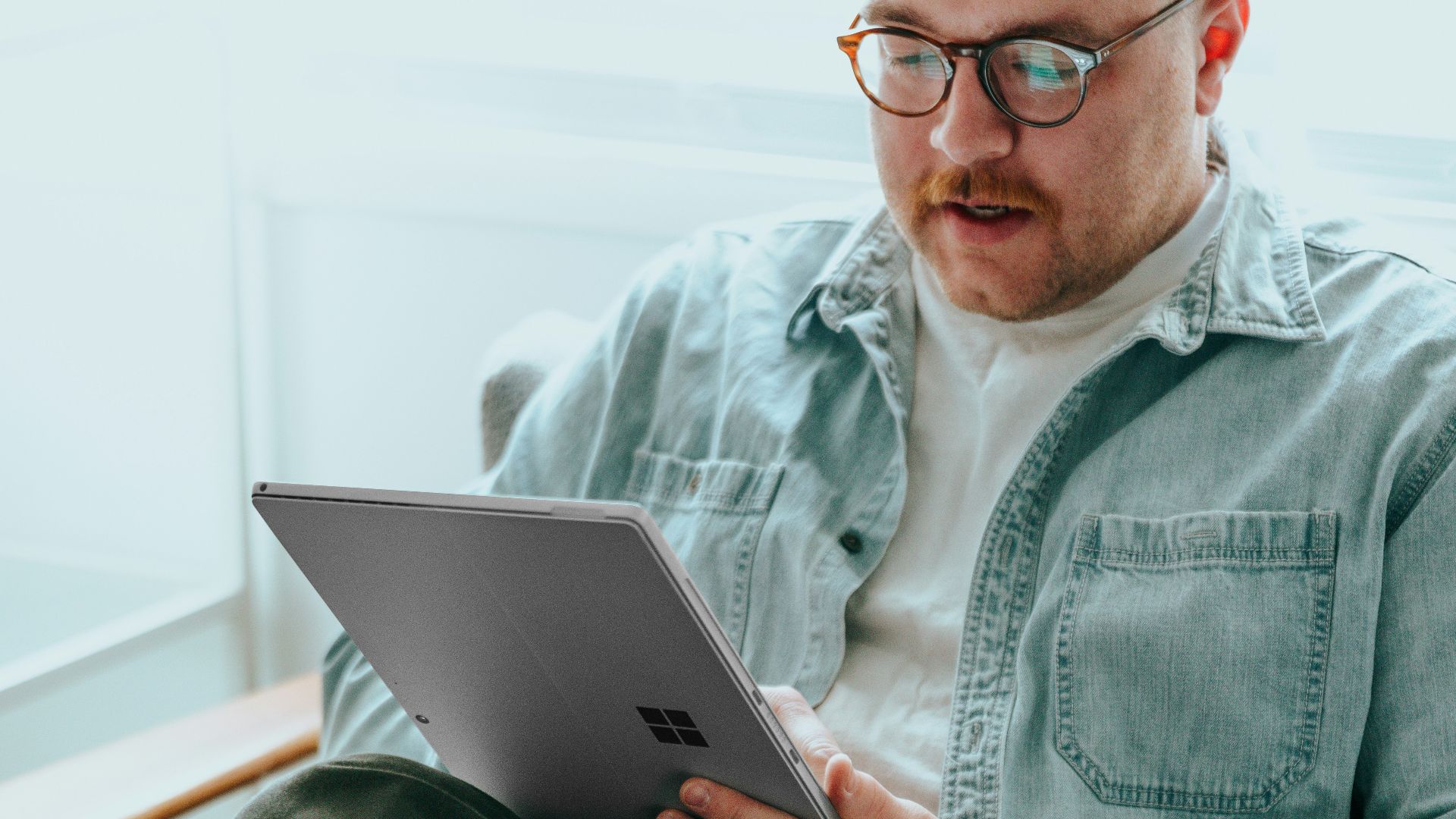 a man sitting on a couch using a laptop computer