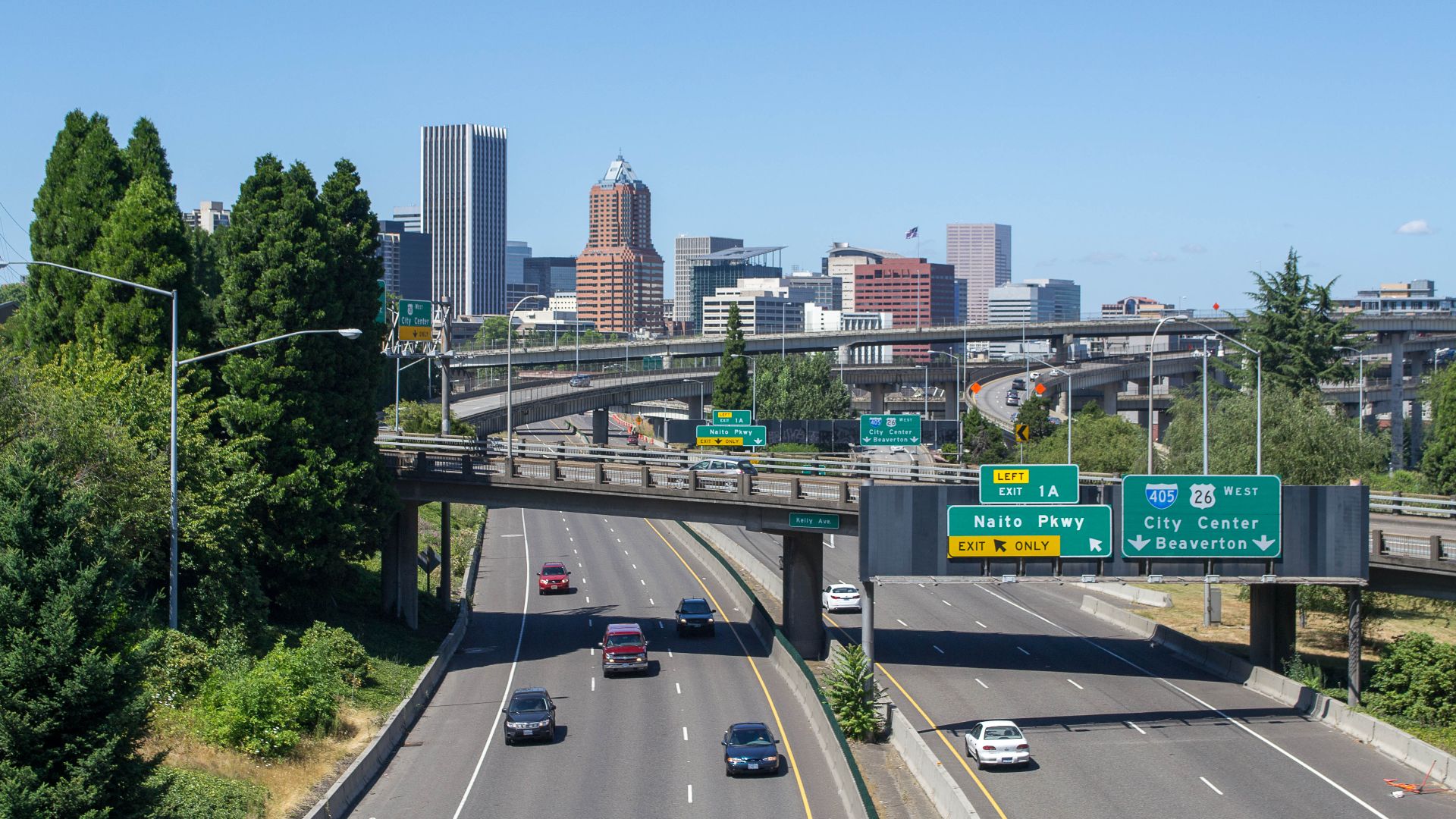 Portland seen from the westernmost section of the Ross Island Bridge, with Interstate 5 in the foreground and the viaducts of the southern I-5/I-405 interchange in the center of the view