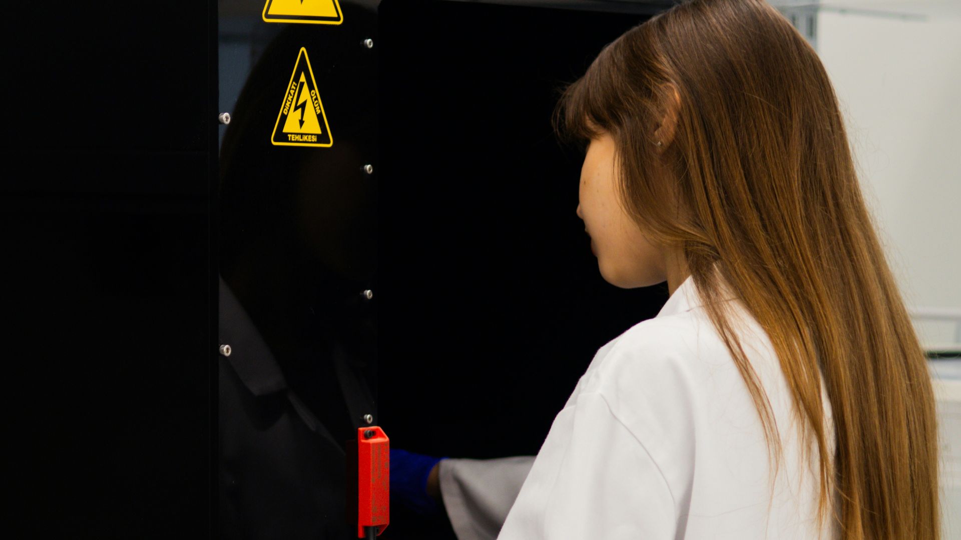 Scientist in lab coat works with equipment