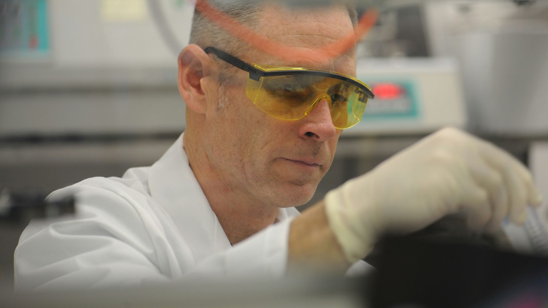 a man in a lab wearing safety goggles