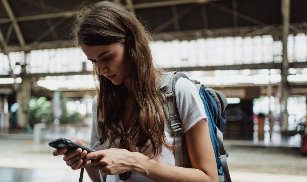 Woman in White Neck T-shirt Using Smartphone